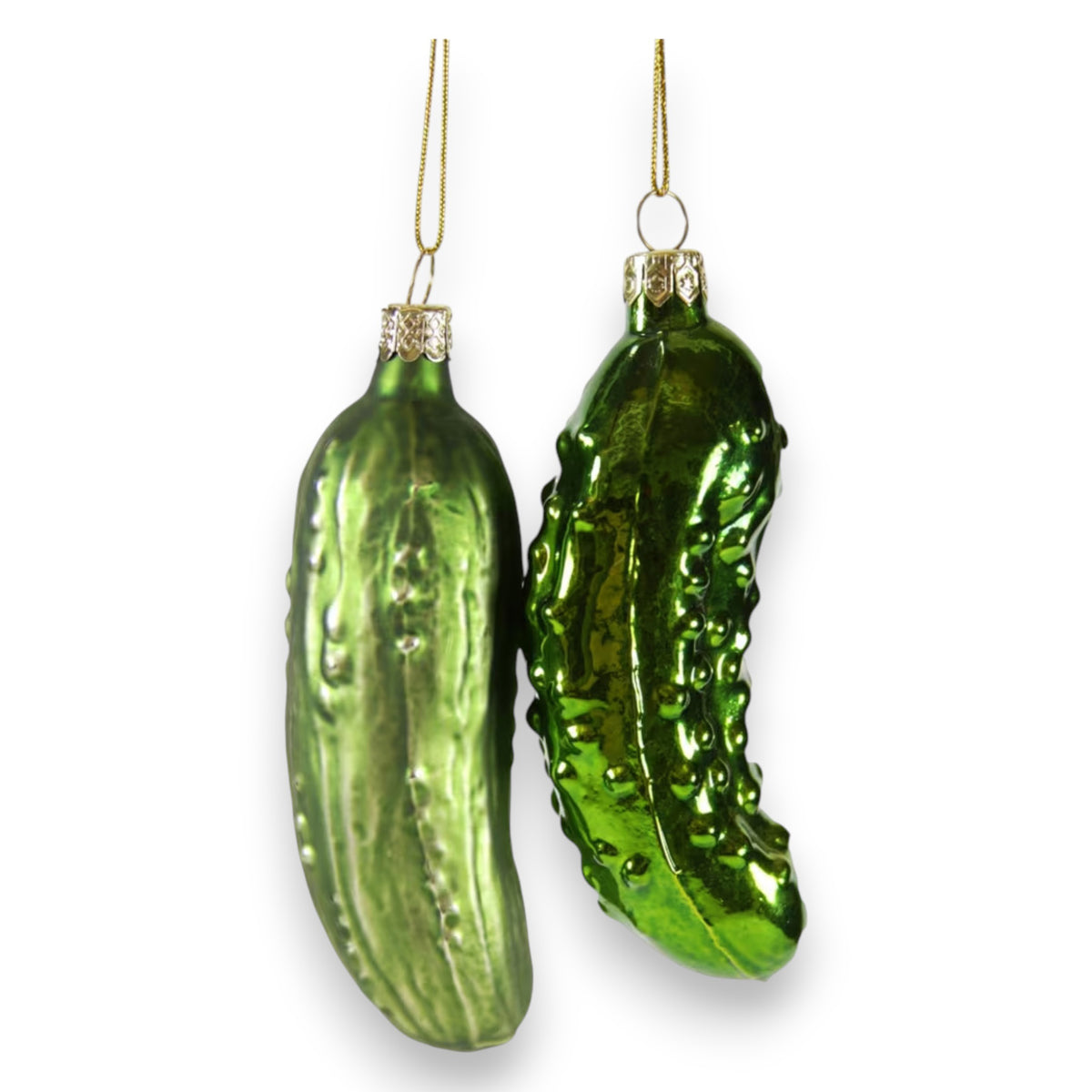 Two shiny green PICKLES ORNAMENT glass decorations by CODY FOSTER hang from gold strings against a white background—ideal gifts for collectors or design lovers.