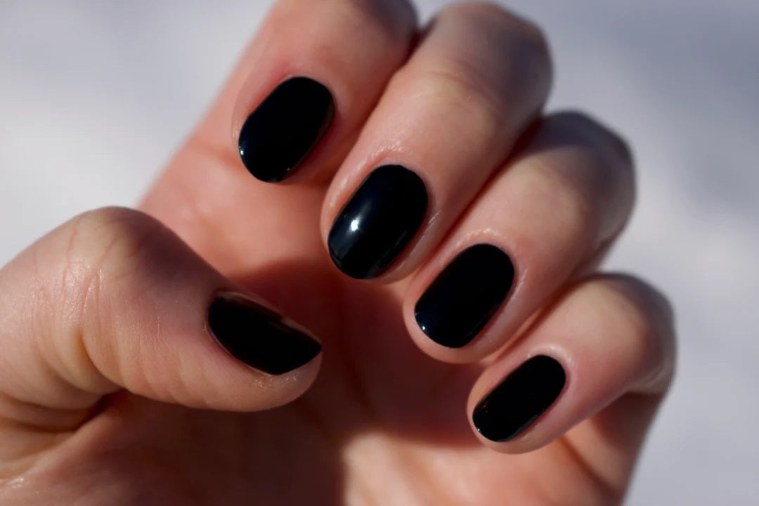 A glass bottle of TENOVERTEN - NAIL POLISH from the brand TEN OVER TEN, featuring a white cap and a dusty pink nail color. The front label displays "TEN OVER TEN" in white uppercase letters. This vegan, eight-free formula ensures both beauty and peace of mind. The background is plain and light-colored.