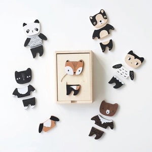 A wooden toy set titled "WEE GALLERY - MIX & MATCH ANIMAL TILES" by WEE GALLERY shown on a white background. The visible toy piece features a cartoonish animal, combining traits of a fox and a bear, painted in brown, white, and black colors. Perfect for creative play and developing motor skills, the toy is presented in a wooden box.