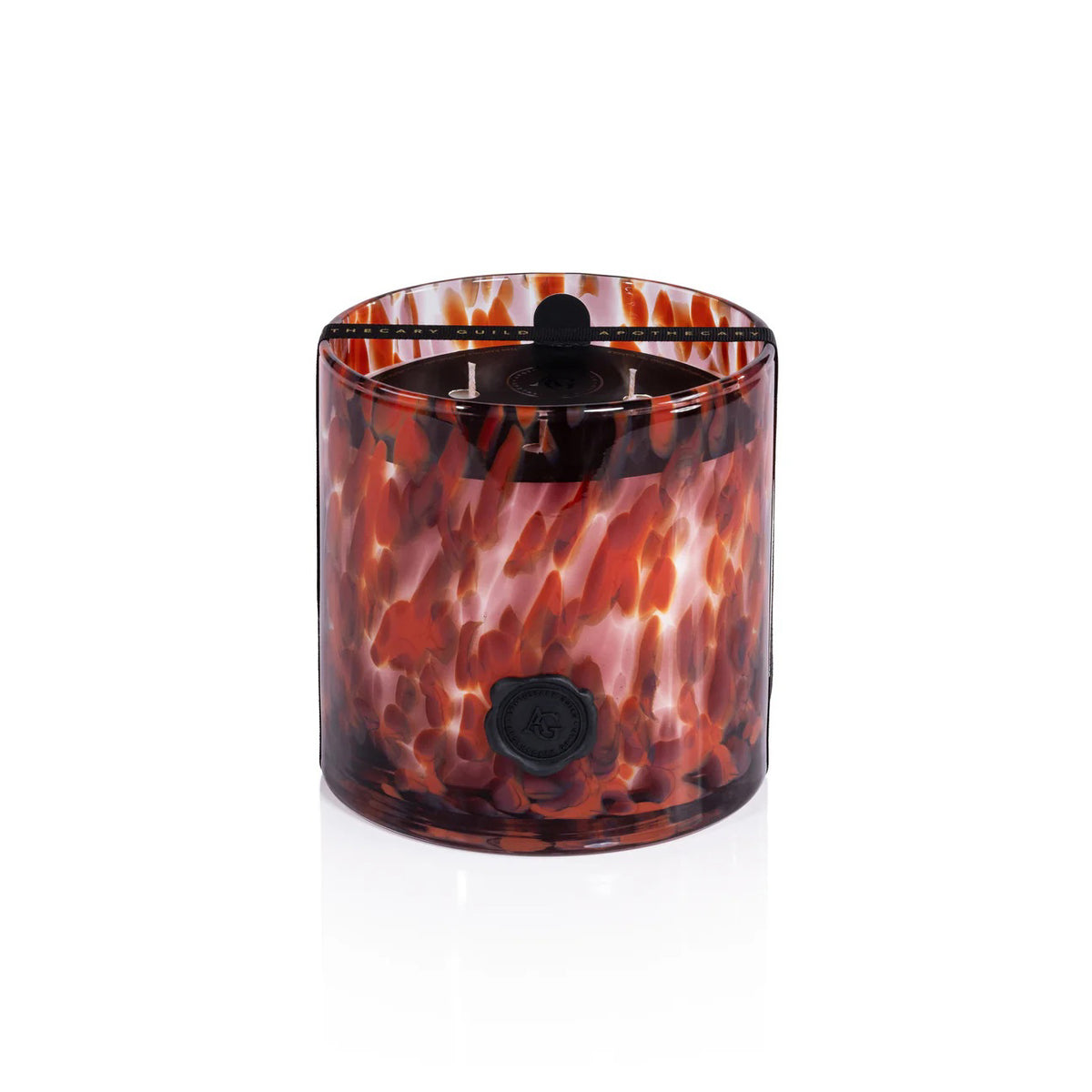 The ZODAX Apothecary Guild Opal Glass 3 Wick Candle in Cardamom Negroni features a marbled brown, orange, and white glass holder with a black emblem, three wicks, and offers a long-lasting burn.