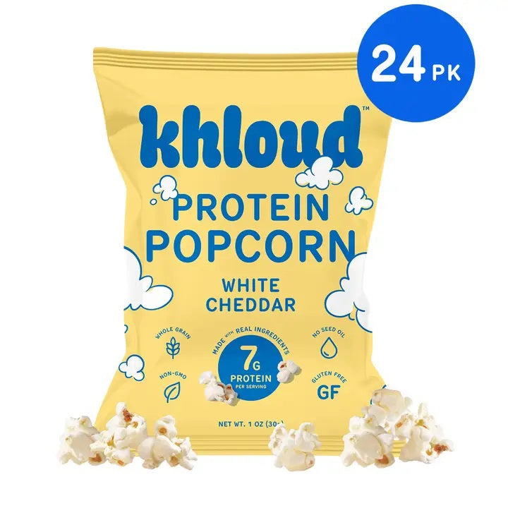 A yellow bag of KHLOUD FOODS’ KHLOUD- WHITE CHEDDAR PROTEIN POPCORN, featuring clouds and popcorn kernels, is labeled with 7g protein, gluten free, and 1oz; a 24-pack icon appears in the top right. This salty snack showcases cheesy white cheddar popcorn scattered at the bottom for a perfect burst of flavor.