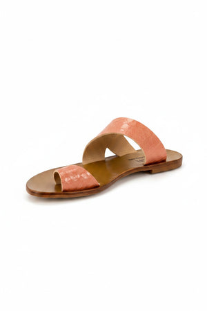 The CYDWOQ SANDAL by CYDWOQ (SIDEWALK) features a single flat slide design with a brown sole and two wide, textured pink straps—one across the toes and another near the instep—highlighting its modern aesthetic against a light background.