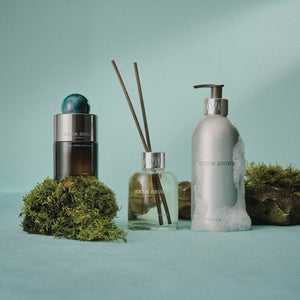 A bottle of MOLTON BROWN COASTAL CYPRESS EAU DE PARFUM, featuring a smoky glass base, silver band, and blue marbled cap, is displayed against a plain white background.