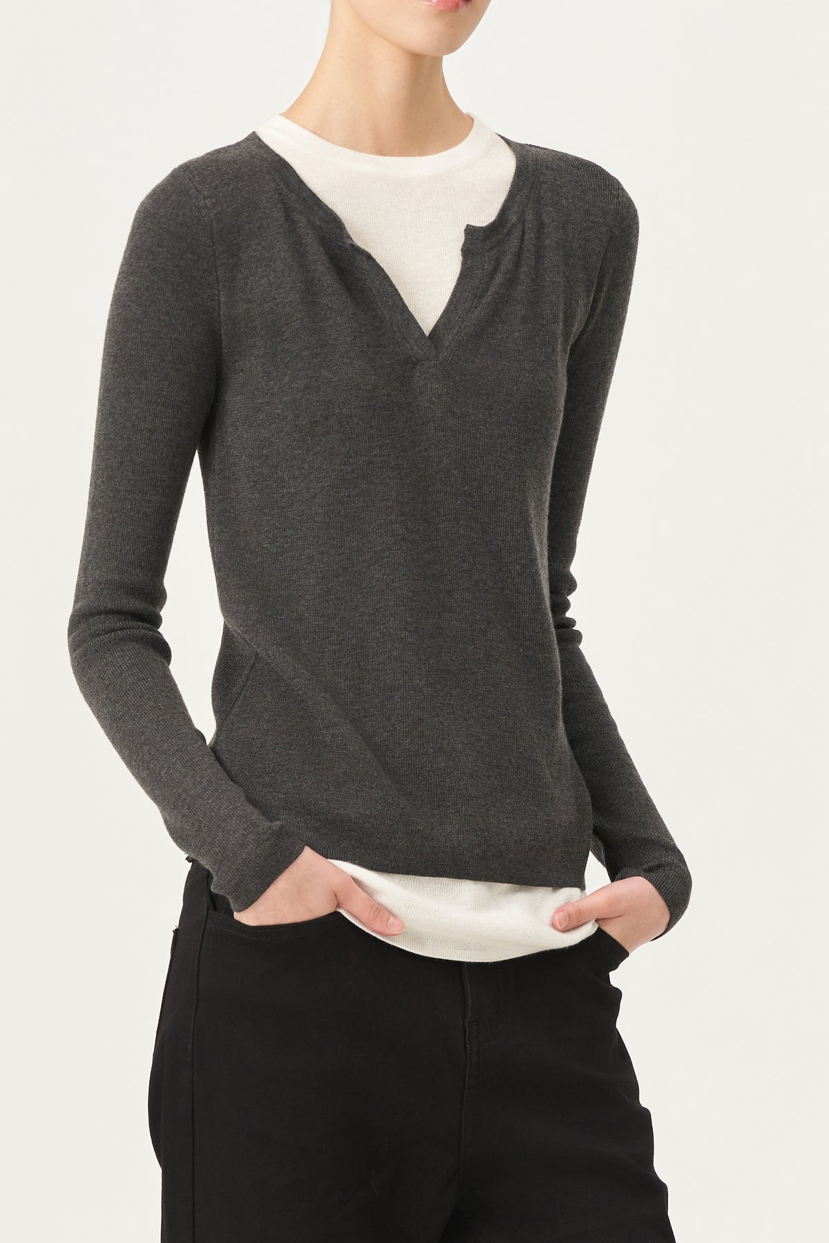 The ELEH - SWEATER WITH BUILT IN T-SHIRT features a charcoal gray sweater with a V-notch neckline layered over an attached white round-neck shirt, both displayed against a plain white background.