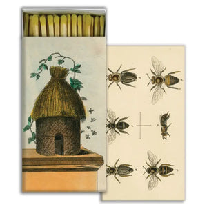 The HOMART MATCHES - HIVE & 6 BEES is a vintage-style match box with a straw beehive and bee illustration, partially open to show safety matches and a bee diagram inside. Measures 4.5 x 2.25 inches—great for collectors or as a hostess gift.
