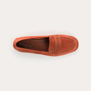 The REQINS HEMA Suede Loafer in Briques, a women’s classic loafer featuring a burnt orange suede upper, penny slot detail, and flat sole, is shown in profile against a white background.