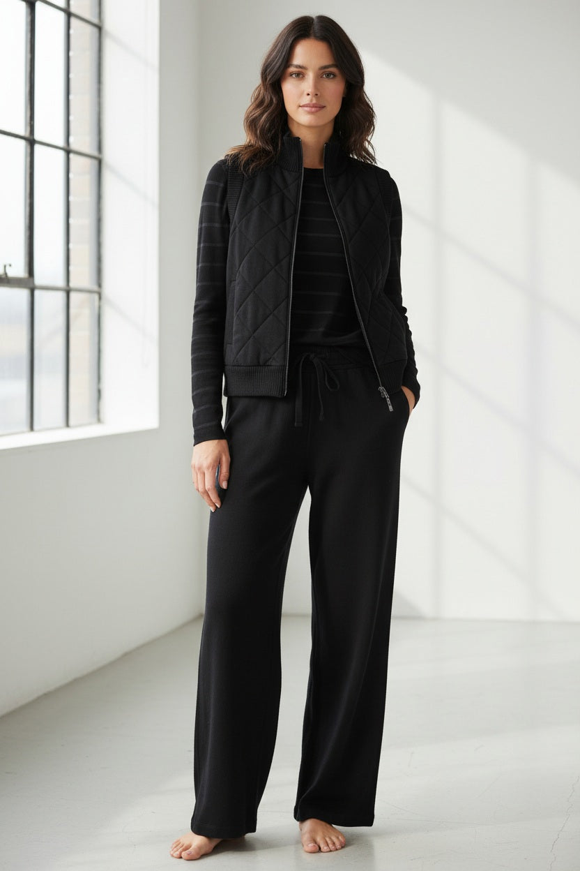 The KINROSS CASHMERE - QUILTED VEST IN BLACK is a luxury sleeveless vest with a front zipper, ribbed collar, armholes, and hem, shown against a white background.