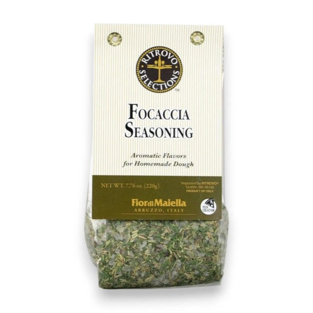 A bag of RITROVO SELECTION - FIOR DI MAIELLA FOCCACIA SEASONING by RITROVO, labeled “Aromatic Flavors for Homemade Dough,” containing visible aromatic herbs. The cream-colored packaging, accented with gold and black, emphasizes that this premium Italian blend is made in Italy.