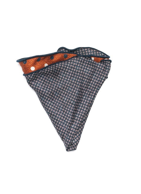 The EDWARD ARMAH Silk Reversible Pocket Circle Rust Polka Dot, featuring white and navy accents with a navy patterned edge, is displayed flat on a white background.
