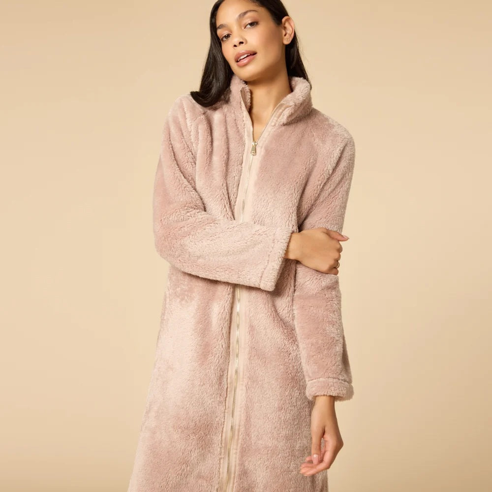 A woman wearing a blush-colored SOFTIES - DREAMPLUSH ZIP ROBE with matching knit socks.