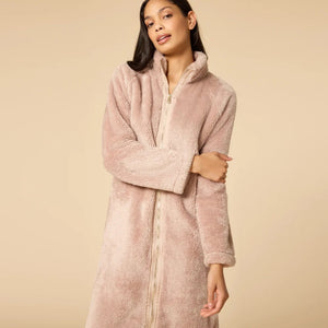 A woman wearing a blush-colored SOFTIES - DREAMPLUSH ZIP ROBE with matching knit socks.