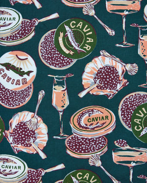 Introducing the PRINTFRESH - CHAMPAGNE & CAVIAR TRAVELER TOTE by PRINTFRESH: a spacious, reusable tote bag with dual handles, adorned with vibrant pomegranates, olives, martini glasses, and decorative labels on a deep green background accented by striped trim. Thoughtfully crafted from organic cotton, this stylish tote delivers both sustainability and flair for your daily journeys.