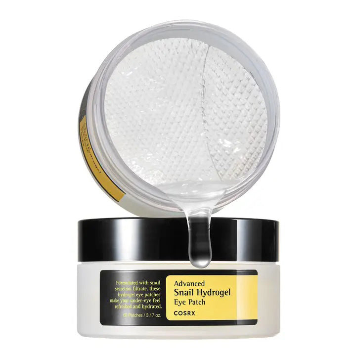 An open container of ASIAN BEAUTY WHOLESALE ADVANCED SNAIL HYDROGEL EYE PATCH 60 PATCHES reveals gel patches inside, with the clear lid above and the label displayed on the white and black jar.