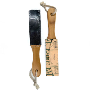 The BAUDELAIRE Bamboo 10" Foot File features a natural pumice surface on one side and a wooden handle with a coarse string loop. Ideal for exfoliating, this product is set against a plain white background.