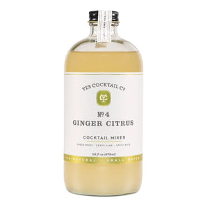 A clear glass bottle with a black cap containing Yes Cocktail Co.'s Ginger Citrus Cocktail Mixer is adorned with a white label featuring green accents. The text indicates it is crafted from fresh root, zesty lime, and has a spicy kick. The bottle holds 16 fl oz (473 ml).