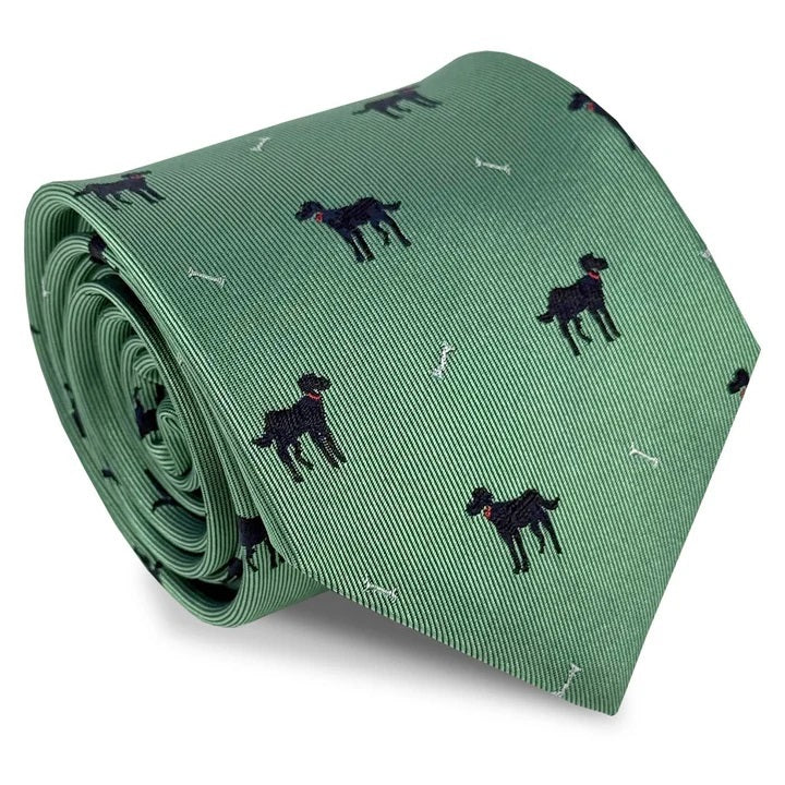 A rolled-up BIRD DOG BAY Black Lab Silk Tie in Mint, featuring a pattern of small black dogs and white bones evenly spaced across the woven silk, crafted in the signature style of BIRD DOG BAY.