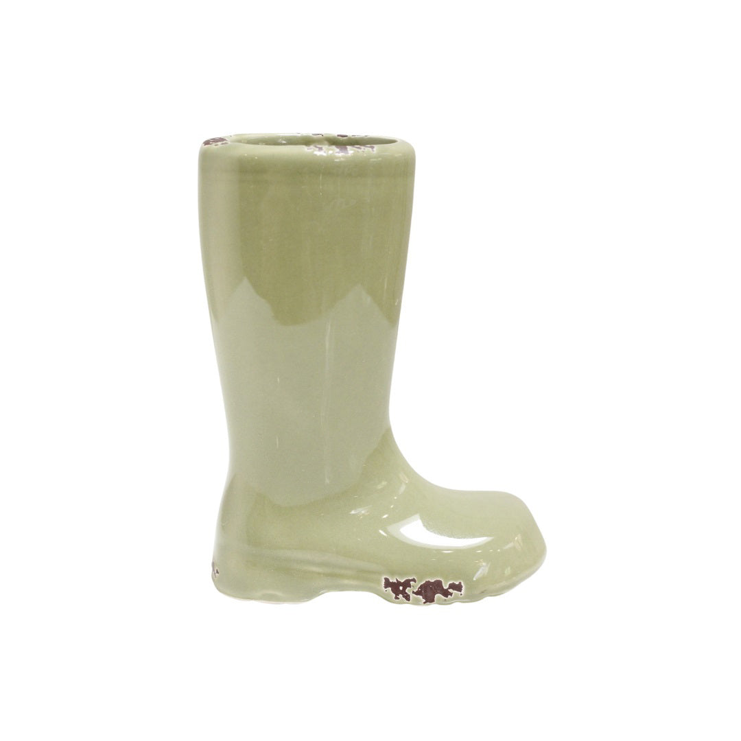 The STONEWARE BOOT VASE (OLIVE) by CREATIVE COOP is a small, light green ceramic planter designed to resemble a rain boot standing upright. Its clean, top opening is ready to hold soil and a small plant. This charming vase features a glossy finish with subtle brown floral accents near the sole, making it an ideal gift for any gardener.