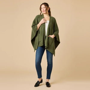 A woman wearing a black SOFTIES - SOLID RIB MARSHMALLOW SHAWL over a grey top and white trousers.