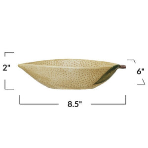 A flat lay features CREATIVE COOP’s HAND-PAINTED STONEWARE LEMON SHAPED BOWL, SMALL—one with oats, one with a grapefruit—plus a lemon-shaped pitcher and ceramic lemons atop a folded striped cloth. A delightful citrus-themed display.