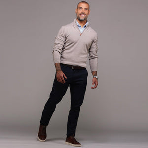 A smiling man with a shaved head and trimmed beard wears the COLLARS AND CO Oatmeal Cashmere Touch Australian Merino Quarter Zip Sweater over a blue checkered shirt, posing against a plain gray background.
