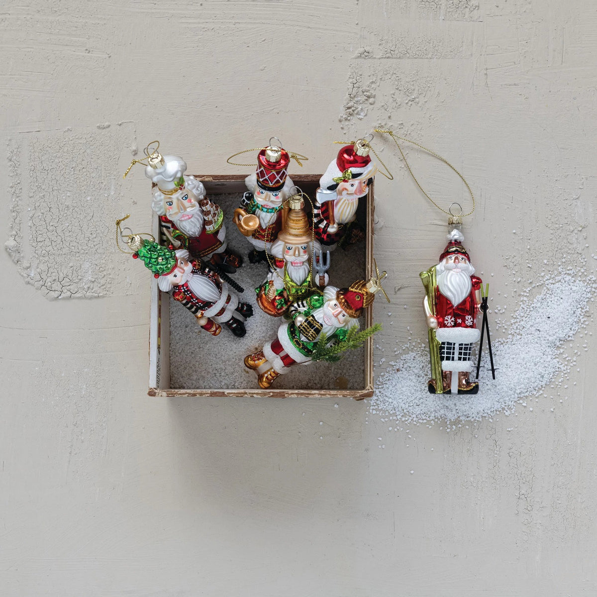 Eight GLASS NUTCRACKER ORNAMENTS by CREATIVE COOP hang in two rows on a white background, each featuring unique Christmas outfits and festive items for an assorted holiday display.