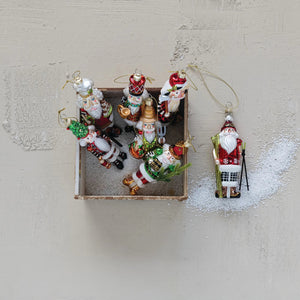 Eight GLASS NUTCRACKER ORNAMENTS by CREATIVE COOP hang in two rows on a white background, each featuring unique Christmas outfits and festive items for an assorted holiday display.