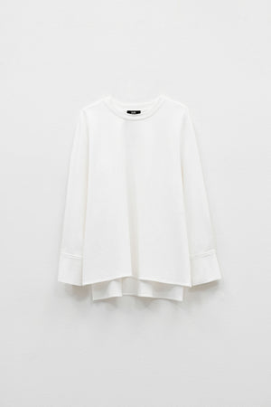 The ELEH - THE BIANCA CUFF TOP by ELEH is a plain white, long-sleeve crew neck shirt with wide sleeves, a loose fit, and an extended back hem for effortless style. Displayed against a white background, this versatile piece features a minimalist silhouette.