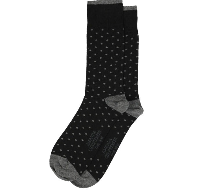 A pair of AMANDA CHRISTENSEN - TRUE DOT MID-CALF SOCKS IN BLACK featuring small white polka dots and contrasting gray toes and heels. Made in Italy from soft combed cotton, these socks have “AMANDA CHRISTENSEN TRUE 41-45” printed on the soles.