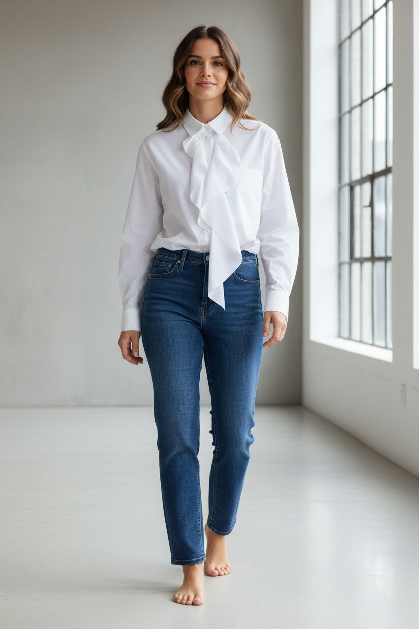 A person is facing away from the camera, wearing the MEIMEIJ - COTTON RUFFLE BLOUSE by MEIMEIJ with beige pants against a plain light background.