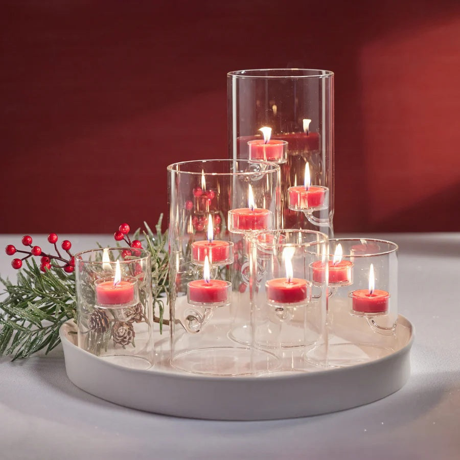 The ZODAX SUSPENDED GLASS TEALIGHT HOLDER - LARGE features a clear cylindrical design with three tealight candles on separate glass arms at varying heights. Its modern minimalist look is also windproof for stylish, functional decor.