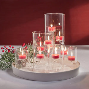 The ZODAX SUSPENDED GLASS TEALIGHT HOLDER - LARGE features a clear cylindrical design with three tealight candles on separate glass arms at varying heights. Its modern minimalist look is also windproof for stylish, functional decor.