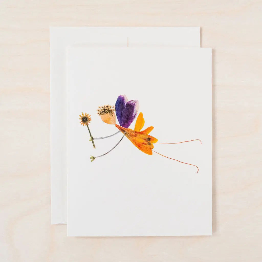 The PETAL PEOPLE PRESS - SPRITE CARD by PETAL PEOPLE PRESS features pressed purple, orange, and yellow petals in a butterfly design with green leaves, displayed on a white base amid scissors and paperclips.