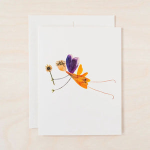 The PETAL PEOPLE PRESS - SPRITE CARD by PETAL PEOPLE PRESS features pressed purple, orange, and yellow petals in a butterfly design with green leaves, displayed on a white base amid scissors and paperclips.