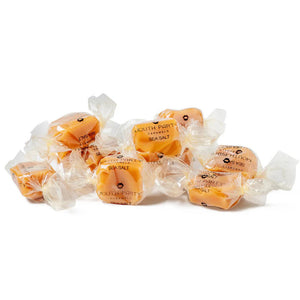 A clear bag of Mouth Party Sea Salt Caramels, tied with a bright pink bow and labeled "MOUTH PARTY - SEA SALT CARAMEL BAG.