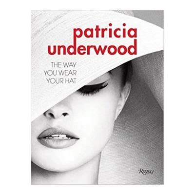 Book cover for "THE WAY YOU WEAR YOUR HAT" by COMMON GROUND DISTRIBUTOR, featuring a monochrome image of a woman adorned with striking makeup and wearing an oversized hat that partially veils her face. The bold red and black text encapsulates the essence of chic elegance.