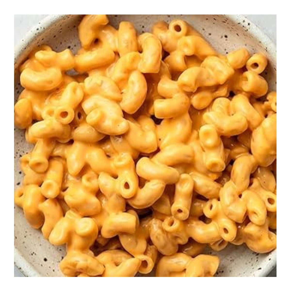 A close-up of KAIZEN FOOD COMPANY's KAIZEN-WHITE CHEDDAR LOW CARB MAC&amp;CHEESE shows elbow pasta coated in a creamy, high-protein, bright orange cheese sauce.