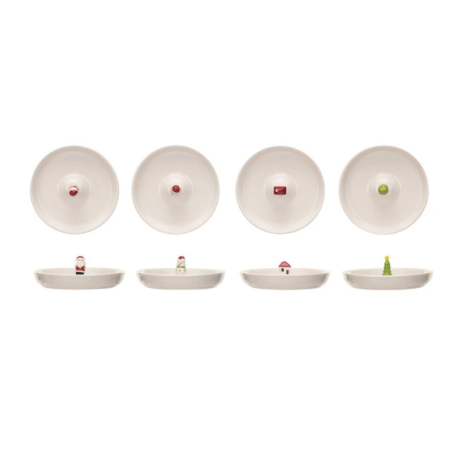 Three CREATIVE COOP STONEWARE DISHES WITH HOLIDAY FIGURES hold cream puffs, mini cupcakes, and crispbread on a wooden table, two stacked with Santa and Christmas tree décor, set against a brick wall backdrop.