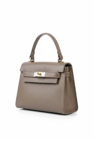 The LE BORSETTE LEATHER SATCHEL BAG is a small, structured satchel-shaped handbag in light pink, featuring a gold clasp at the front. It boasts a single top handle, an adjustable shoulder strap, and two gold-tone hardware pieces on either side of the handle. The textured leather adds to its luxurious and elegant appearance against the plain white background.