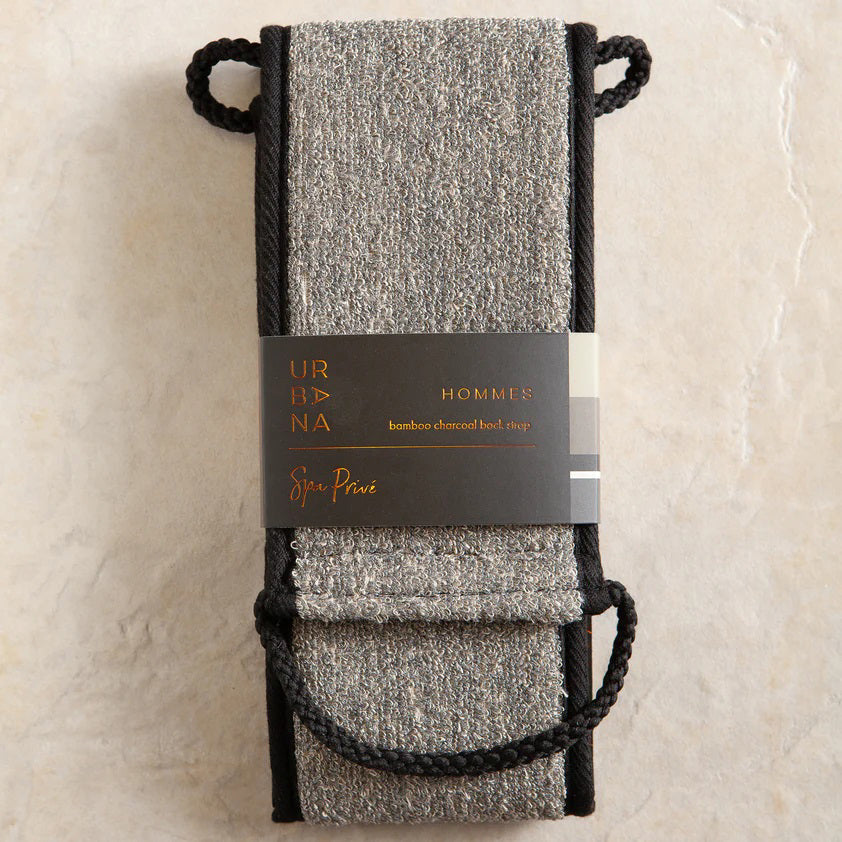 The BAMBOO CHARCOAL BACK SCRUBBER by EUROPEAN SOAPS, LLC is a rectangular, grey synthetic cleaning cloth with black trim. It is folded over and features black looped handles on both ends for an easy grip during use. The texture of the cloth appears to be suitable for gentle cleaning or polishing dead skin cells away.