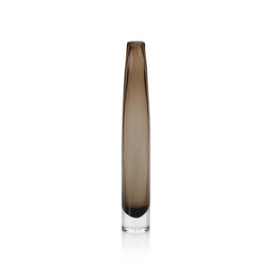 The ZODAX TATE Slim Glass Taupe Vase - Tall features a narrow cylindrical design in smoky brown glass with a clear base, ideal for display on a glass shelf against a plain white background.