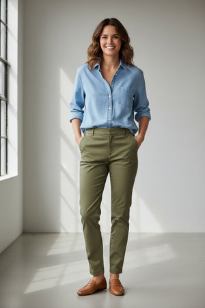 The FRANK & EILEEN Eileen Relaxed Button Up in Famous Denim Classic Wash is a light blue, long-sleeve shirt with bust-flattering buttons, a chest pocket, rolled sleeves, and a curved hem, shown against a white background.