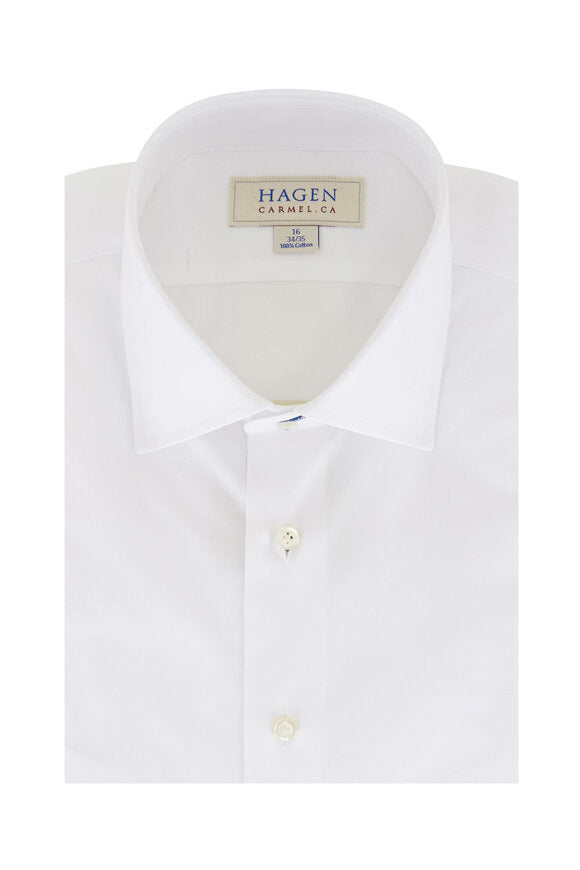 Close-up of the HAGEN - COTTON DRESS SHIRT IN WHITE, neatly folded with a modern spread collar and white buttons. A label inside the collar displays "HAGEN.