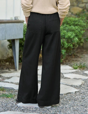 A person wearing the FRANK & EILEEN Madeline Patch Pocket Pull On Pant in Famous Denim Black styled with a beige knit sweater, shown from waist to mid-thigh.