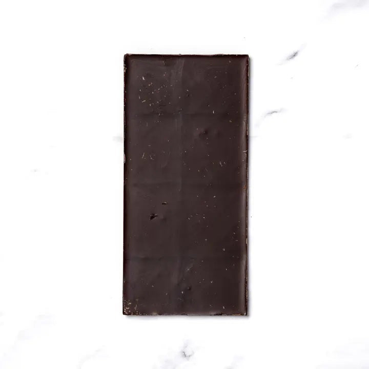 The RITUAL CHOCOLATE - JUNIPER LAVENDER CHOCOLATE bar by RITUAL CHOCOLATE features a purple wrapper with lavender, butterflies, and gold accents. This 70% cacao dark chocolate weighs 2.12 oz (60g) and includes juniper berries and lavender.
