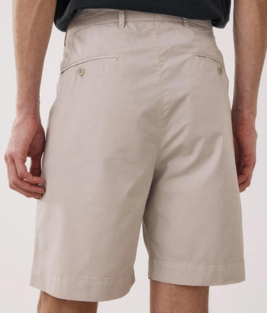A person models the HARTFORD - TAYLOR SHORTS IN STONE by HARTFORD, shown in light beige against a plain white background. The image is cropped to display only the lower torso and legs.