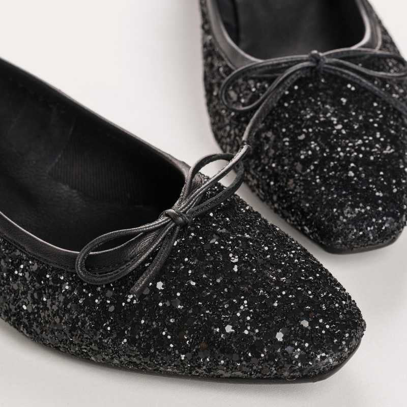 A single REQINS - FETICHE GLITTER HEELED BALLERINA shoe, black and covered in glitter, viewed from above with a small bow on the toe and &quot;REQINS&quot; on the insole—perfect elegant party shoes.