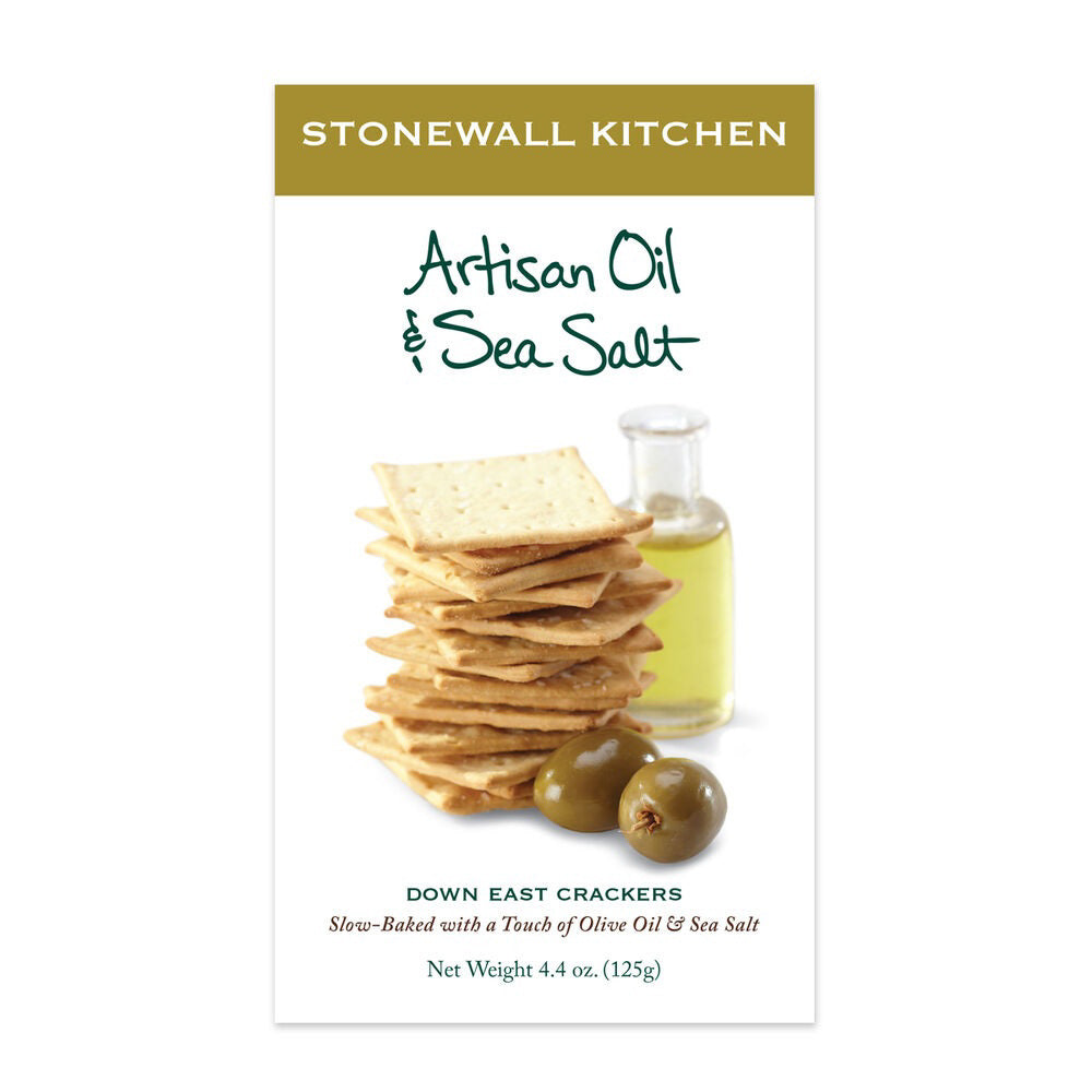 A box of STONEWALL KITCHEN - ARTISAN OIL AND SEA SALT CRACKERS. The packaging showcases a stack of square olive oil crackers next to two olives and a small bottle of olive oil, labeled "Slow-Baked with a Touch of Olive Oil &amp; Sea Salt." Perfect for pairing with aged cheeses. Net weight: 4.4 oz (125g).