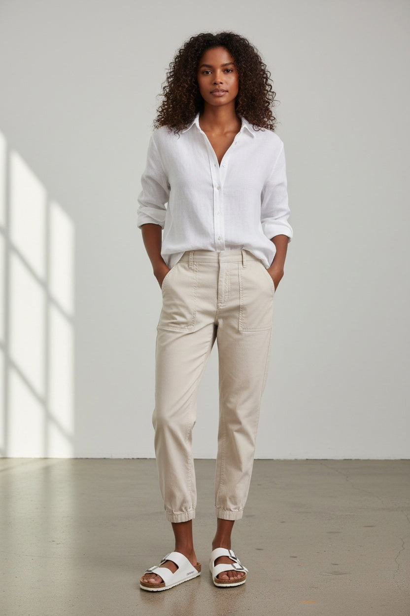 The FRANK &amp; EILEEN JAMESON UTILITY JOGGER in Cement is a beige, high-rise jogger made from soft Italian Performance Linen, featuring a tapered ankle, two large front pockets, button-zip closure, and belt loops.