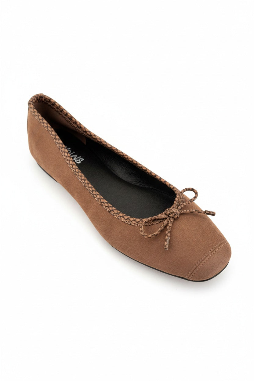 The REQINS - HARMONY suede ballerina flats with python trim in Muscade, by REQINS, are pictured in side view against a white background. These brown flats feature a braided python-print trim around the opening and are adorned with a small bow on top.