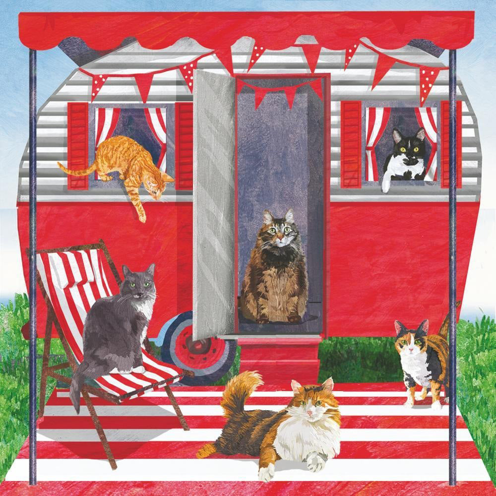 The CAMPER CATS BEVERAGE NAPKINS by PAPER PRODUCTS DESIGN feature a charming illustration of a red and white retro camper decorated with bunting. The scene includes several cats lounging in various spots: one relaxing in a deck chair, another on the camper step, two looking out from windows, one jumping down, and another resting on a red and white striped mat. The backdrop is complete with lush green grass and a clear blue sky.